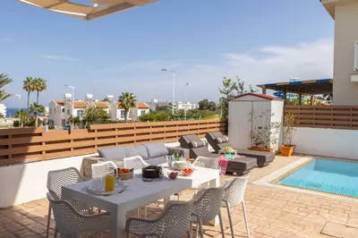 a patio with a table and chairs and a pool at Villa Protaras View 9 Central Protaras -Fig Tree Bay-Jacuzzi-Hot Tub in Protaras