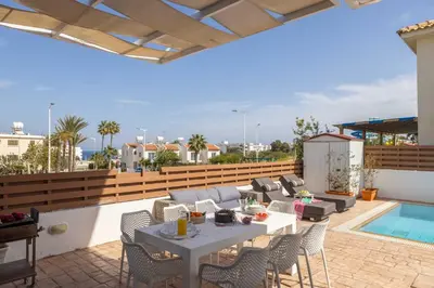 a patio with a table and chairs and a pool at Villa Protaras View 9 Central Protaras -Fig Tree Bay-Jacuzzi-Hot Tub in Protaras