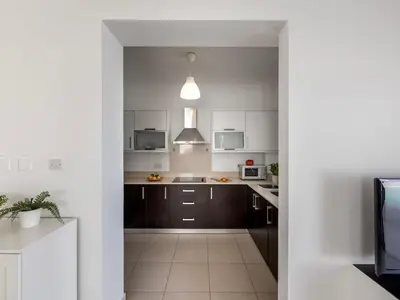 a kitchen with brown cabinets and white appliances at villa Sama palms 21 in Protaras