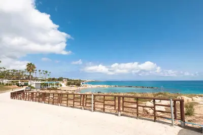 a beach with a wooden fence and the ocean at Apartment Marisol - Beachfront in Protaras