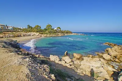 a person is standing on a rocky beach at Apartment Marisol - Beachfront in Protaras