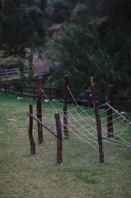 a wooden fence with a net in the grass at Private Glamping Cabin for Family Getaway with BBQ in Arakapas