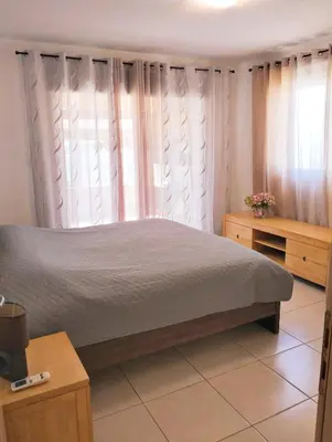 a bedroom with a large bed with white curtains at Nissi Area,Ground Floor Flat, Free internet in Ayia Napa
