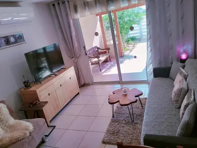 a living room with a couch and a tv at Nissi Area,Ground Floor Flat, Free internet in Ayia Napa