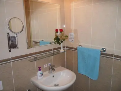 a bathroom with a sink and a mirror and a blue towel at Nissi Area,Ground Floor Flat, Free internet in Ayia Napa