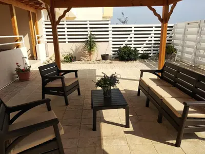 a patio with benches and a table and a fence at Nissi Area,Ground Floor Flat, Free internet in Ayia Napa