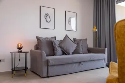 a grey couch in a living room with a table at City Hall Suites in Limassol