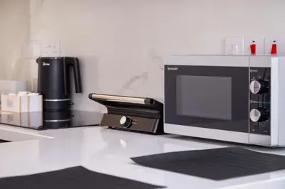 a microwave sitting on a counter next to a coffee maker at City Hall Suites in Limassol