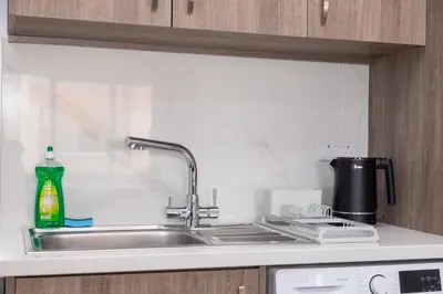 a kitchen sink with a bottle of detergent next to it at City Hall Suites in Limassol