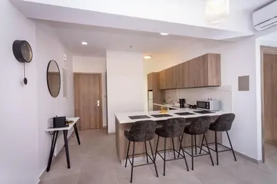 a kitchen with a counter and bar stools at City Hall Suites in Limassol