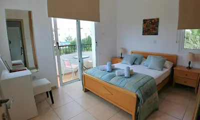 a bedroom with a bed and a balcony at Oresti Villa with a pool in Paralimni