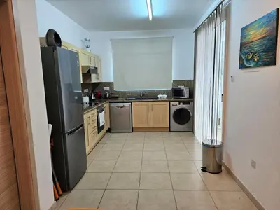 a kitchen with a black refrigerator and a tile floor at Oresti Villa with a pool in Paralimni