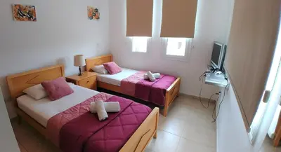 a bedroom with two beds and a television in it at Oresti Villa with a pool in Paralimni