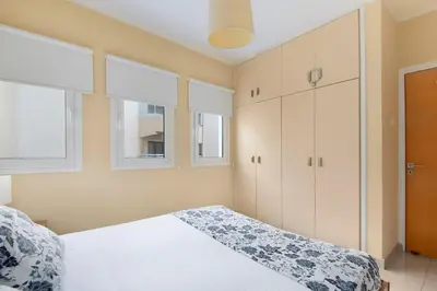 a bedroom with a white bed and two windows at City Center, Nice View, 2BR in Larnaka