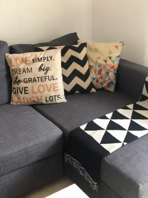 a gray couch with pillows on top of it at Mythical Sands Resort, Protaras, Choose Joy Apt in Paralimni