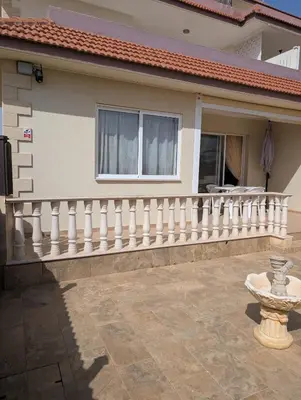 a white railing on a house with a balcony at St Andrews Apartment in Xylophaghou