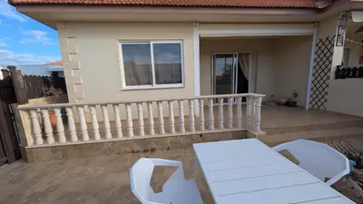 a patio with two chairs and a table on a balcony at St Andrews Apartment in Xylophaghou