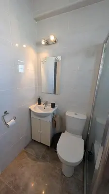 a bathroom with a toilet and a sink at St Andrews Apartment in Xylophaghou