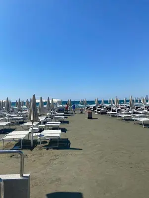 a bunch of lounge chairs and umbrellas on a beach at Limassol Star Complex Seaview Apartment in Limassol