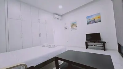 a white room with two beds and a tv at STAY Cypress Studio in Limassol