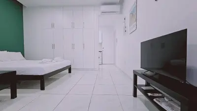 a white room with a bed and a flat screen tv at STAY Cypress Studio in Limassol