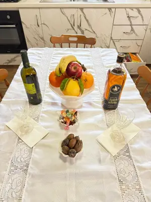 a table with a plate of fruit and bottles of wine at Little Paradise in Sotira