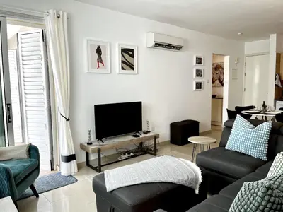 a living room with a couch and a tv at STAY Chromata Lagoon Apartment in Protaras