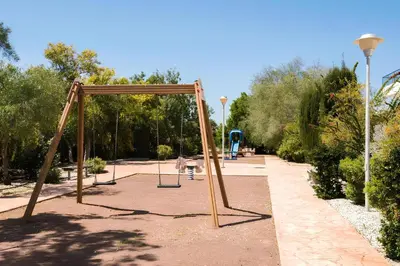 a swing set in a park with trees at STAY Chromata Lagoon Apartment in Protaras