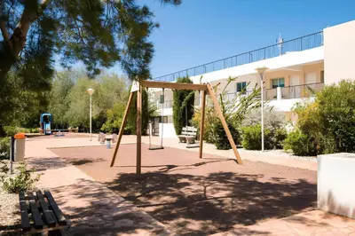 a swing set in a park next to a building at STAY Chromata Lagoon Apartment in Protaras