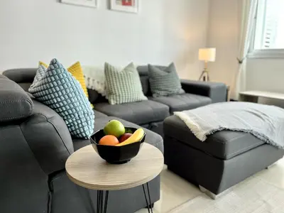 a living room with a couch and a bowl of fruit on a table at STAY Chromata Lagoon Apartment in Protaras