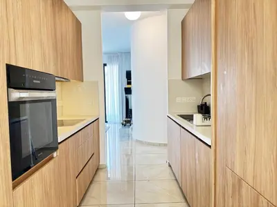 a kitchen with wooden cabinets and a large appliance at Wealthystays Premium Residence in Nicosia