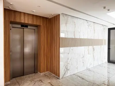 an elevator lobby with a metal door and marble wall at Wealthystays Premium Residence in Nicosia