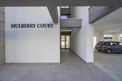 a building with a car parked in a parking lot at Mulberry Court Premium Apartments in Limassol