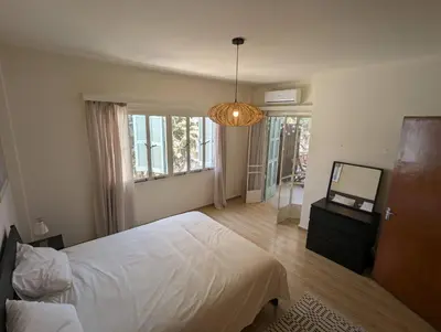 a bedroom with a white bed and a chandelier at Gladstone Apartment by Tangerine in Nicosia
