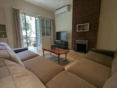 a living room with a couch and a fireplace at Gladstone Apartment by Tangerine in Nicosia