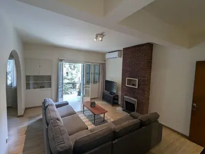 a living room with a couch and a fireplace at Gladstone Apartment by Tangerine in Nicosia