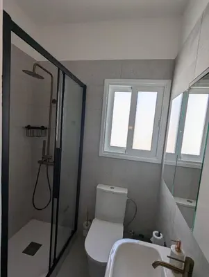 a bathroom with a shower and a toilet and a sink at Gladstone Apartment by Tangerine in Nicosia