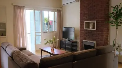 a living room with a couch and a tv at Gladstone Apartment by Tangerine in Nicosia