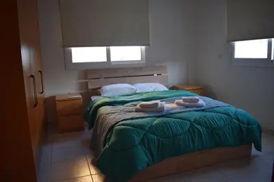 a bedroom with a bed with two towels on it at Trinity Blue Apt in Paralimni