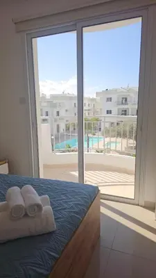 a bedroom with two towels on a bed with a large window at Obv 3206 in Pyla