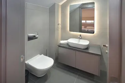 a bathroom with a toilet and a sink and a mirror at Sun and Moon Luxury Villas Ayia Napa in Ayia Napa