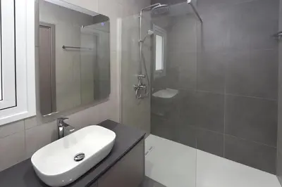 a white bathroom with a sink and a shower at Sun and Moon Luxury Villas Ayia Napa in Ayia Napa