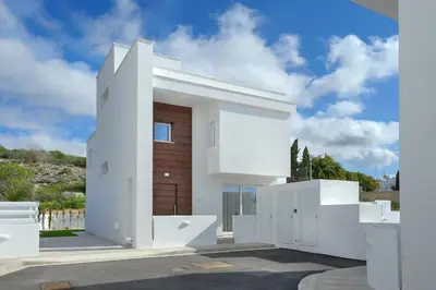 a white house with a wooden door at Sun and Moon Luxury Villas Ayia Napa in Ayia Napa