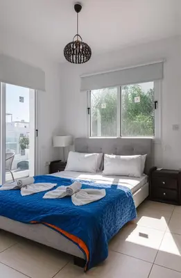 a bedroom with a large bed with towels on it at Nissini Villas in Ayia Napa