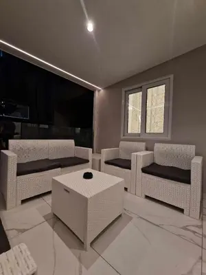 a living room with white chairs and a table at 3 rooms modern apartment close to the beach! in Larnaka