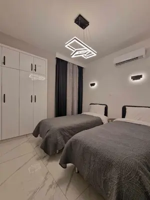 a bedroom with two beds and a chandelier at 3 rooms modern apartment close to the beach! in Larnaka