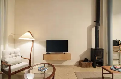 a living room with a tv and a chair and a fireplace at Timeless Gem in Old Nicosia in Nicosia