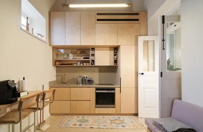 a small kitchen with wooden cabinets and a door at Timeless Gem in Old Nicosia in Nicosia