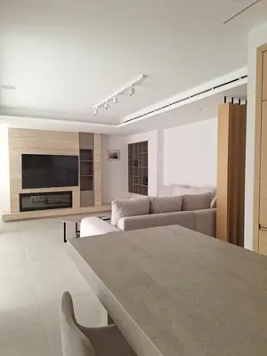 a living room with couches and a tv and a table at Deluxe Seafront - 2 Bed in Limassol