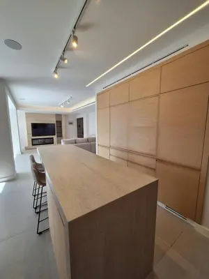 a large kitchen with wooden cabinets and a large island at Deluxe Seafront - 2 Bed in Limassol
